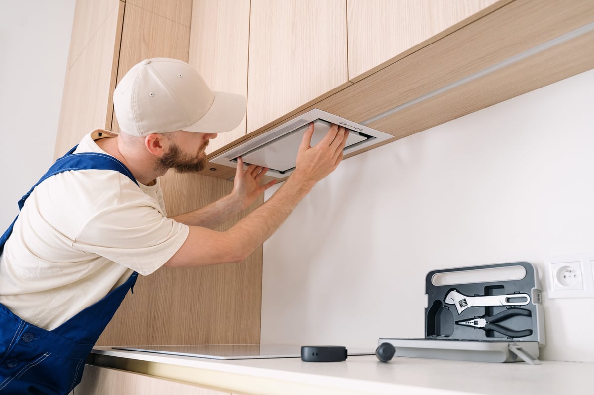 Professional handyman installing range hood